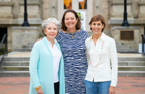 Mary Anne Dickson ’63, Molly Froelich ’83 and Aurelia Monk ’85 standing in front of a building on campus