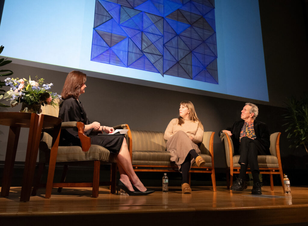 Lecture presenters, Liza Roberts, Leigh Suggs and Thomas Sayre, seated on stage in discussion