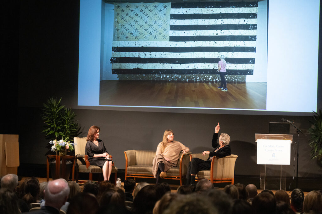 Lecture presenters, Liza Roberts, Leigh Suggs and Thomas Sayre, seated on stage in discussion