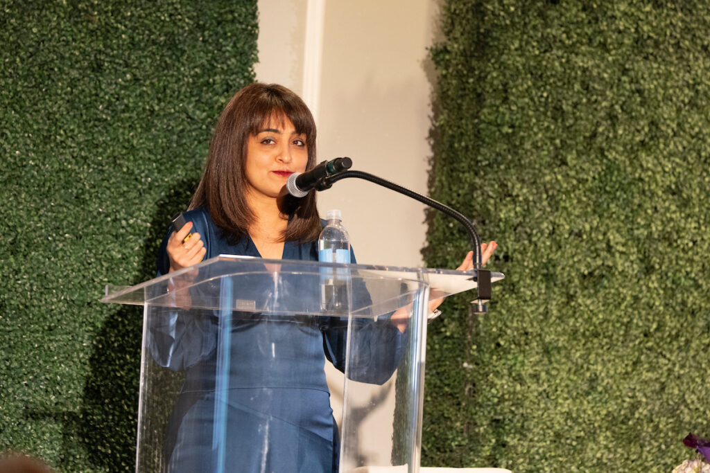 Associate Dean Shimul Melwani on stage presenting